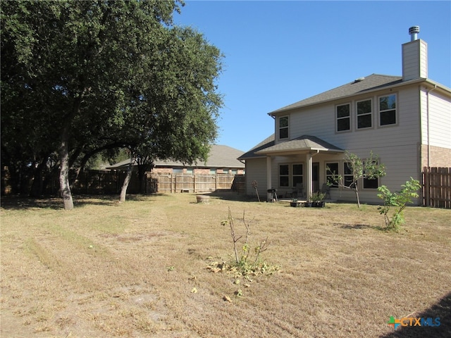 rear view of property featuring a patio and a lawn