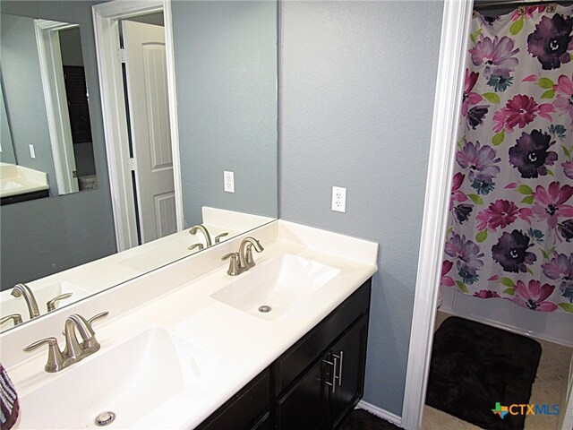 bathroom featuring vanity and curtained shower