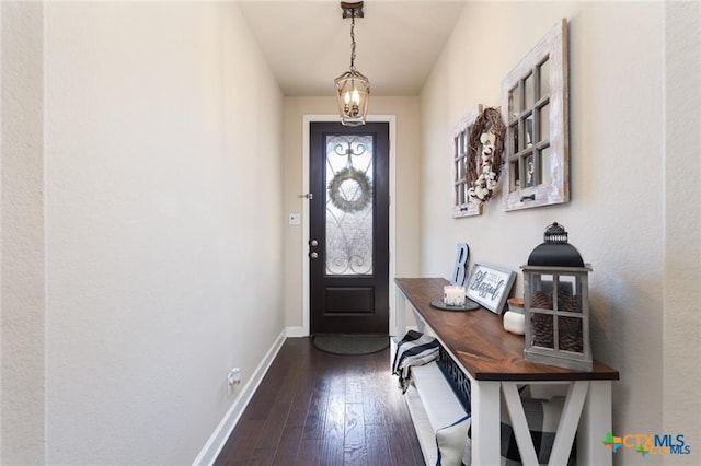 doorway featuring dark wood-style flooring and baseboards