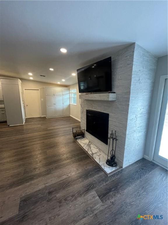 unfurnished living room featuring dark wood-style floors, recessed lighting, and a fireplace