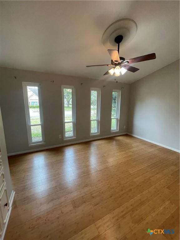 empty room with a ceiling fan, baseboards, and light wood finished floors