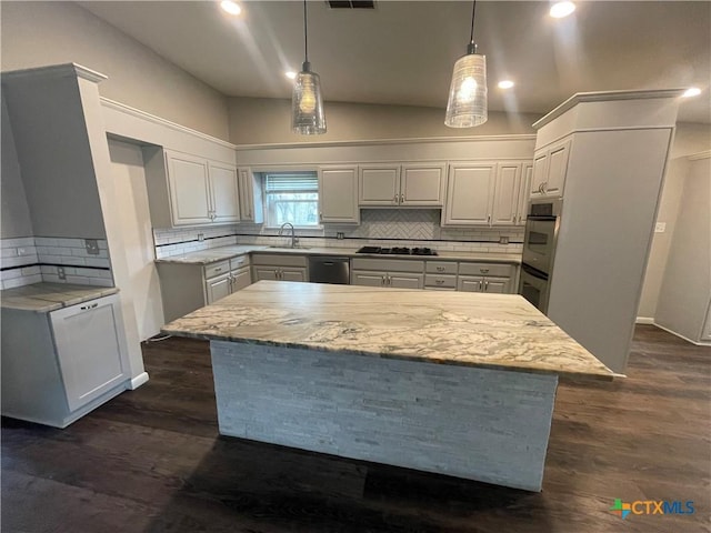 kitchen with white cabinets, dark wood-style floors, decorative light fixtures, stainless steel appliances, and a sink