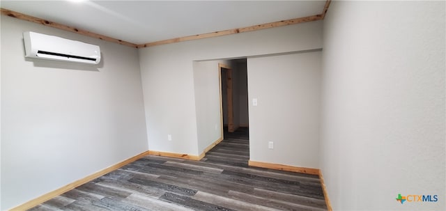 unfurnished room featuring dark hardwood / wood-style flooring and a wall mounted air conditioner