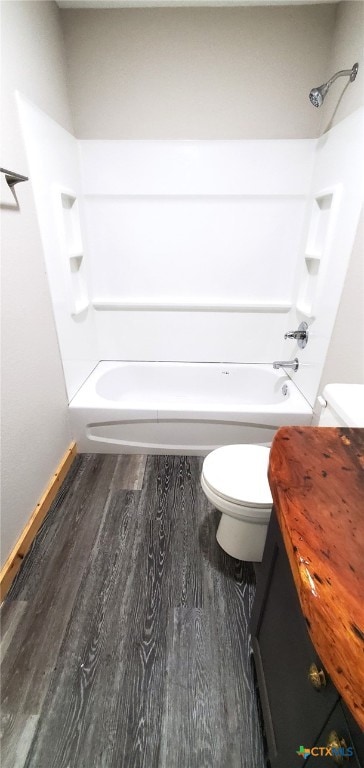 bathroom with hardwood / wood-style flooring, toilet, and  shower combination