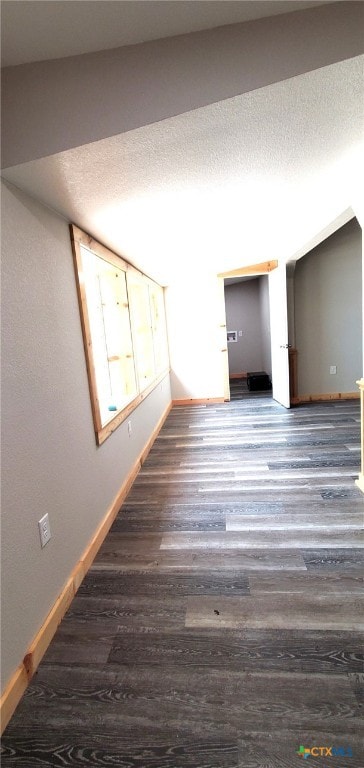 unfurnished room with dark wood-type flooring and a textured ceiling