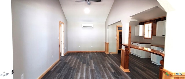 corridor featuring dark wood-type flooring, vaulted ceiling, and a wall mounted air conditioner