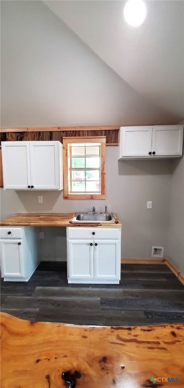 kitchen featuring white cabinetry, dark hardwood / wood-style flooring, lofted ceiling, and sink