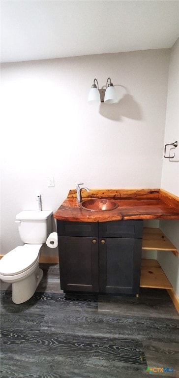 bathroom with hardwood / wood-style floors, vanity, and toilet