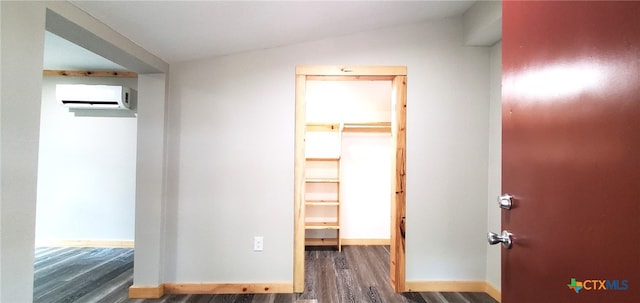 interior space with a wall unit AC, dark hardwood / wood-style flooring, and lofted ceiling