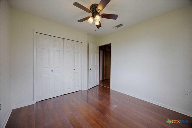 1001 US Highway 77 N, Hallettsville, TX 77964 - unfurnished bedroom with wood finished floors, baseboards, a closet, and a ceiling fan