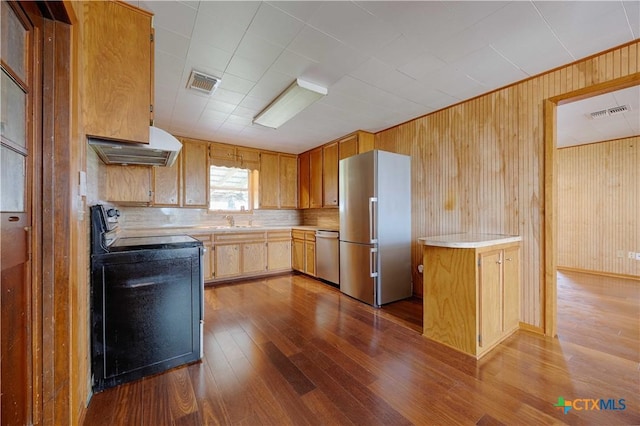 1001 US Highway 77 N, Hallettsville, TX 77964 - kitchen featuring appliances with stainless steel finishes, dark wood-style flooring, under cabinet range hood, light countertops, and a sink