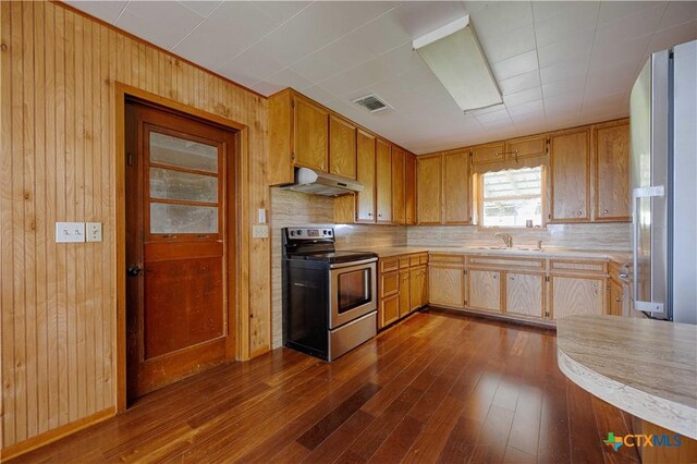 1001 US Highway 77 N, Hallettsville, TX 77964 - kitchen featuring appliances with stainless steel finishes, under cabinet range hood, a sink, light countertops, and wood walls
