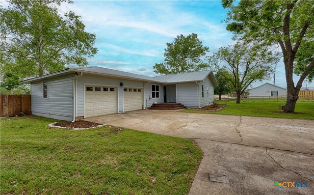 1001 US Highway 77 N, Hallettsville, TX 77964 - single story home with concrete driveway, an attached garage, and metal roof