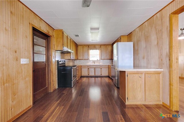 1001 US Highway 77 N, Hallettsville, TX 77964 - kitchen with stainless steel electric stove, under cabinet range hood, freestanding refrigerator, dark wood-type flooring, and light countertops