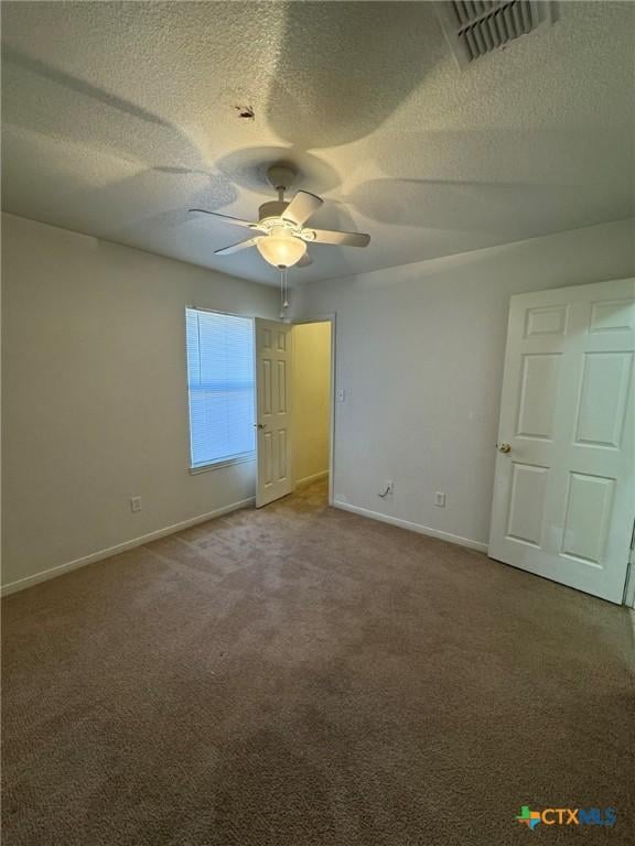 unfurnished bedroom with ceiling fan, carpet floors, and a textured ceiling