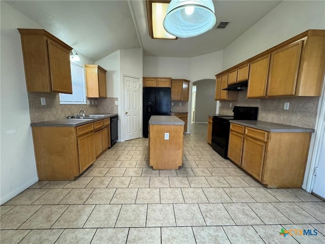 kitchen featuring lofted ceiling, sink, a center island, decorative backsplash, and black appliances