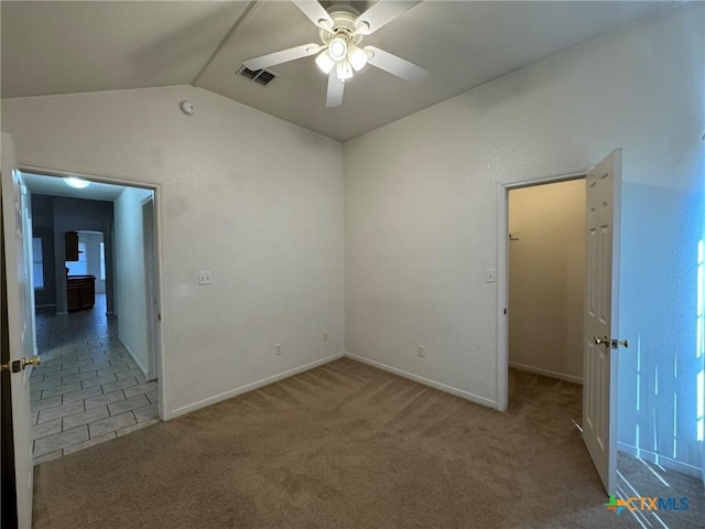 spare room with vaulted ceiling, ceiling fan, and carpet flooring