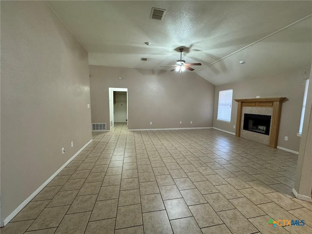 unfurnished living room featuring ceiling fan, vaulted ceiling, a tile fireplace, and light tile patterned floors