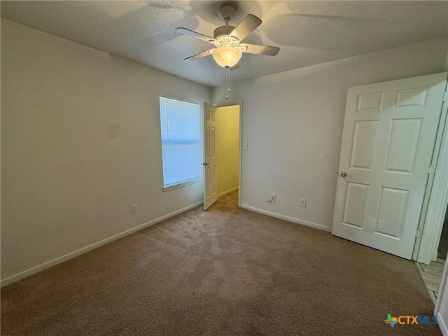 unfurnished bedroom with ceiling fan, light colored carpet, and a textured ceiling