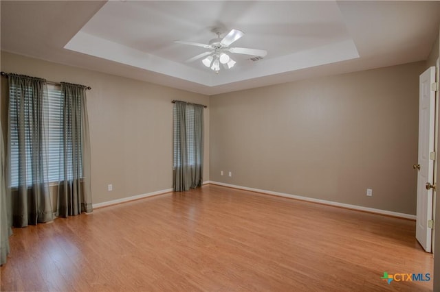 106 Fieldstone, Victoria, TX 77901 - unfurnished room with a tray ceiling, ceiling fan, and light wood-style flooring