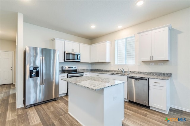 kitchen featuring white cabinets, stainless steel appliances, and hardwood / wood-style flooring