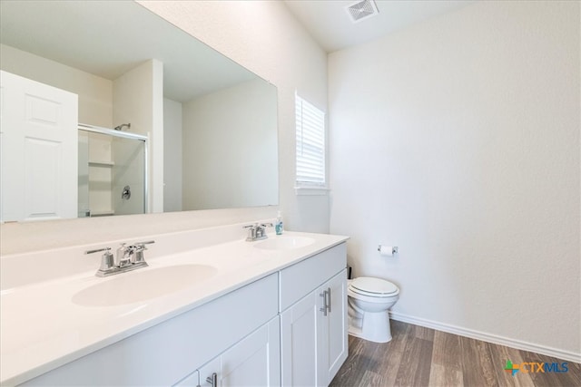 bathroom with vanity, hardwood / wood-style flooring, toilet, and a shower with door