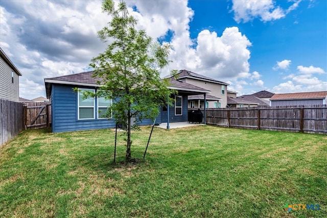 back of house featuring a lawn and a patio area