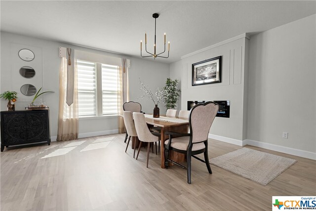 dining space with hardwood / wood-style flooring and a notable chandelier