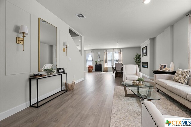 living room featuring wood-type flooring and a notable chandelier