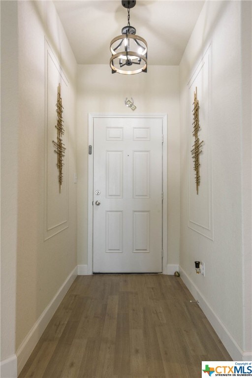 doorway featuring dark hardwood / wood-style floors and an inviting chandelier