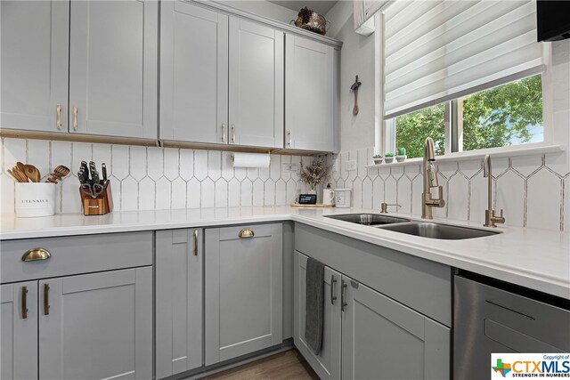 kitchen with dark hardwood / wood-style flooring, gray cabinetry, backsplash, and sink