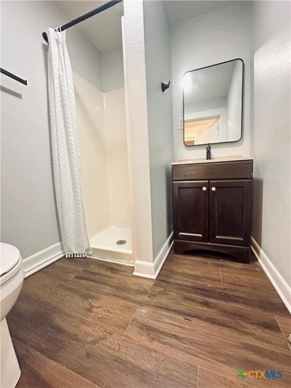 207 Schrimsher St, Yoakum, TX 77995 - full bathroom featuring a shower stall, wood finished floors, and vanity