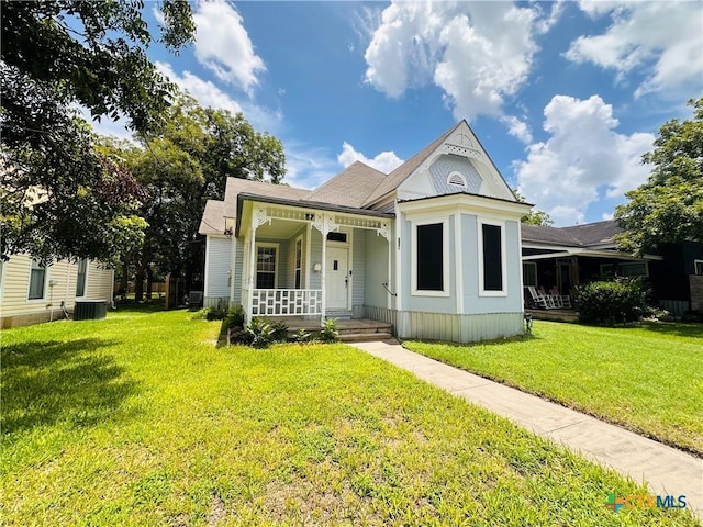 207 Schrimsher St, Yoakum, TX 77995 - victorian-style house featuring covered porch, a front yard, and a shingled roof