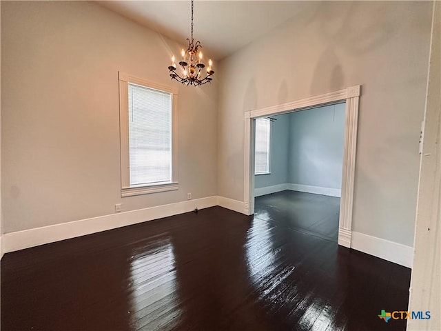 207 Schrimsher St, Yoakum, TX 77995 - spare room featuring a chandelier, dark wood-style floors, and lofted ceiling