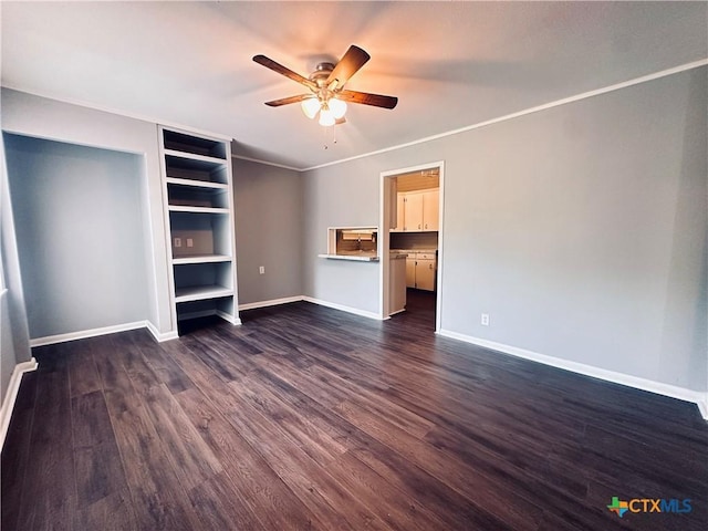 207 Schrimsher St, Yoakum, TX 77995 - unfurnished living room featuring a ceiling fan, dark wood-style floors, built in shelves, and ornamental molding