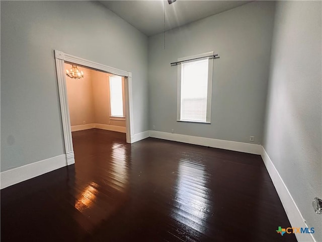 207 Schrimsher St, Yoakum, TX 77995 - empty room featuring hardwood / wood-style flooring and a chandelier