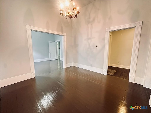 207 Schrimsher St, Yoakum, TX 77995 - empty room with dark wood-style flooring, a towering ceiling, and a chandelier