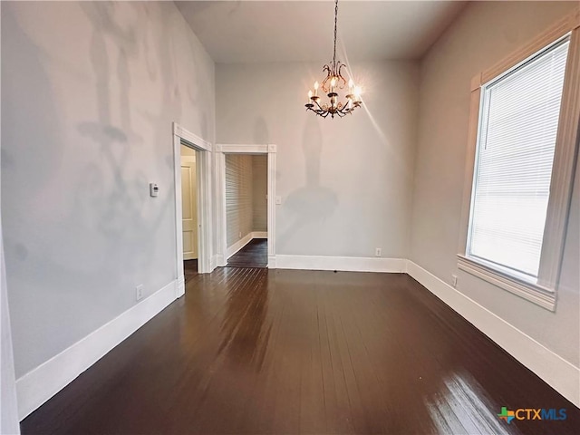 207 Schrimsher St, Yoakum, TX 77995 - unfurnished room with a chandelier and dark wood-style flooring