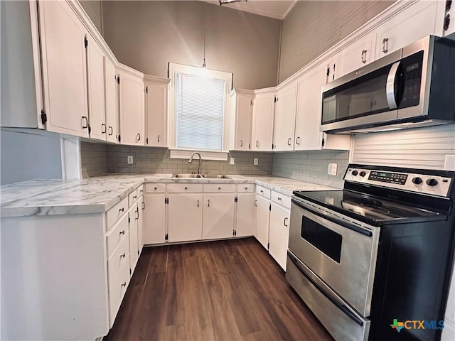 207 Schrimsher St, Yoakum, TX 77995 - kitchen featuring stainless steel appliances, dark wood-style floors, white cabinets, and backsplash