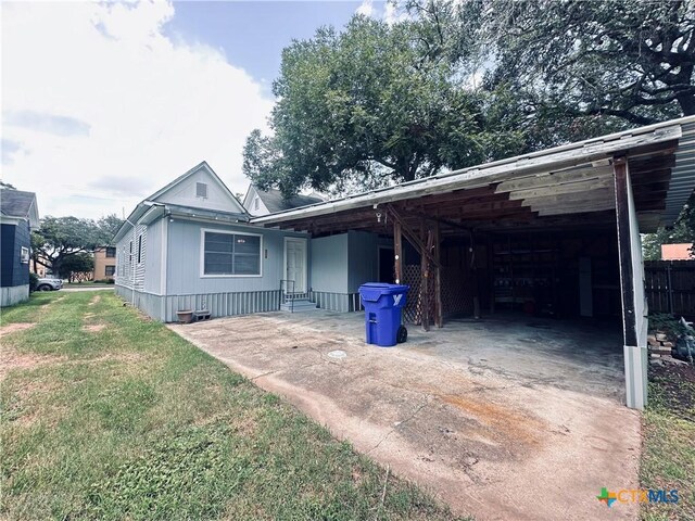 207 Schrimsher St, Yoakum, TX 77995 - view of front of property featuring concrete driveway, a front lawn, and an attached carport