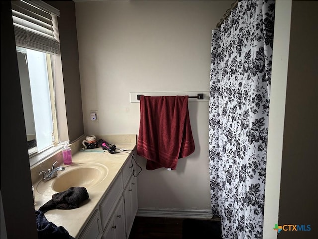 full bath featuring vanity, curtained shower, and a healthy amount of sunlight