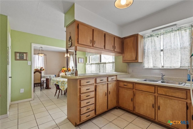 2080 Allison Rd, Martindale, TX 78655 - kitchen with light countertops, a peninsula, brown cabinets, and healthy amount of natural light