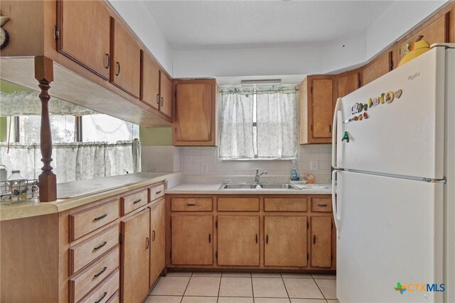 2080 Allison Rd, Martindale, TX 78655 - kitchen featuring freestanding refrigerator, light countertops, brown cabinetry, and backsplash