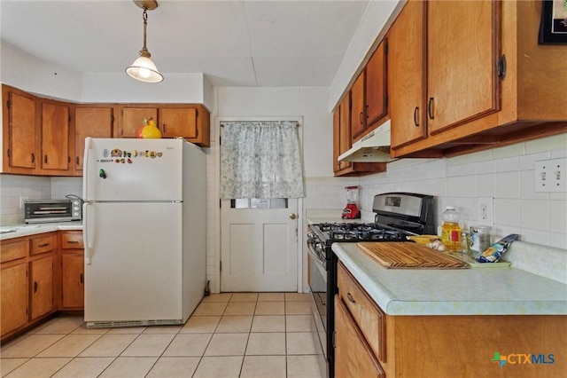 2080 Allison Rd, Martindale, TX 78655 - kitchen featuring freestanding refrigerator, gas stove, under cabinet range hood, brown cabinets, and light countertops