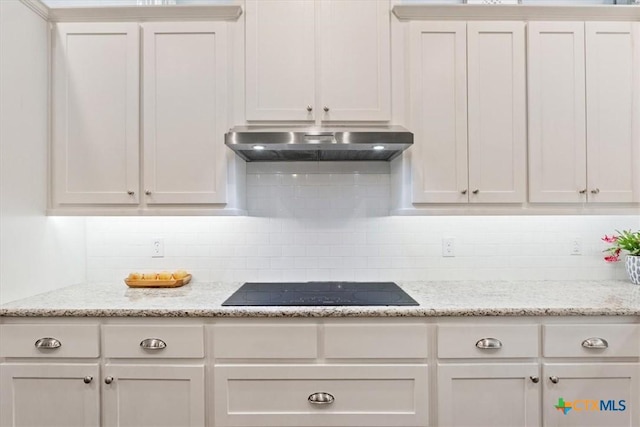 kitchen featuring backsplash, black electric cooktop, light stone counters, and white cabinets