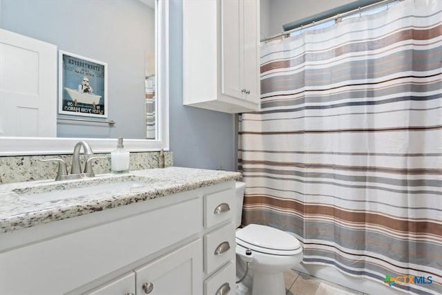 bathroom with tile patterned floors, vanity, and toilet