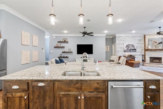 kitchen featuring sink, a center island with sink, and ornamental molding