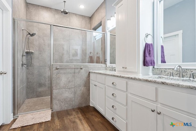 bathroom with vanity, wood-type flooring, and walk in shower