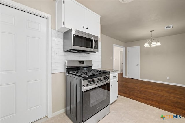 3102 Taft St, Killeen, TX 76543 - kitchen with stainless steel appliances, baseboards, a chandelier, white cabinetry, and decorative backsplash