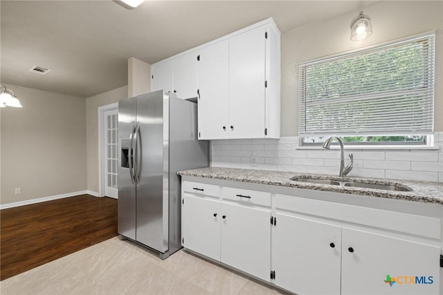 3102 Taft St, Killeen, TX 76543 - kitchen featuring stainless steel refrigerator with ice dispenser, a sink, backsplash, and white cabinetry